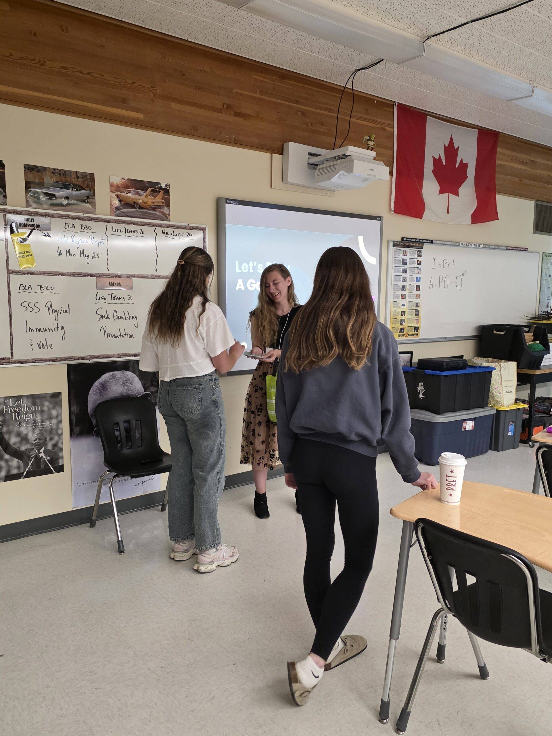 Elementary school classroom with students at the front of a class participating with a presenter who is speaking about gambling Elementary school classroom with students at the front of a class participating with a presenter who is speaking about gambling